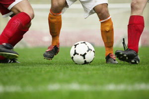 Soccer Player Dribbling Between Defenders